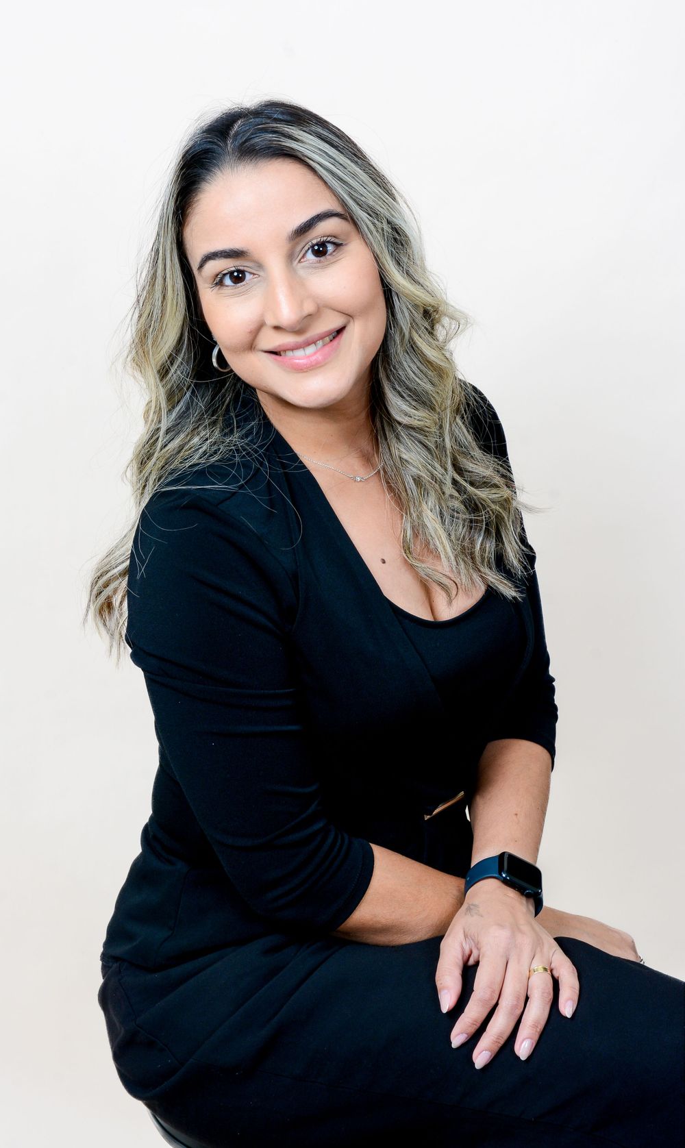 Lifestyle portrait session in black attire against white studio backdrop.