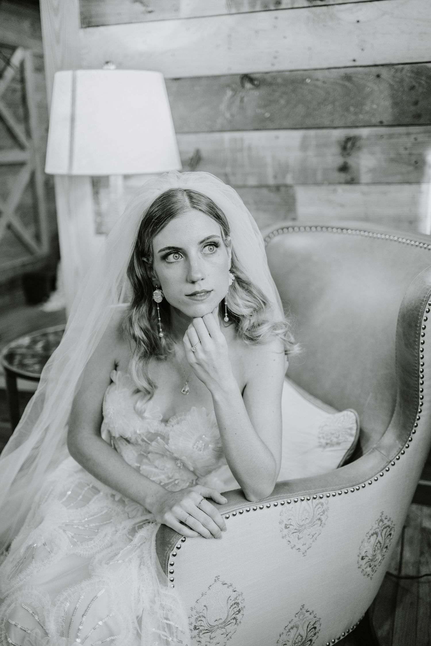 Elegant bridal portrait in a vintage chair with lace dress details.