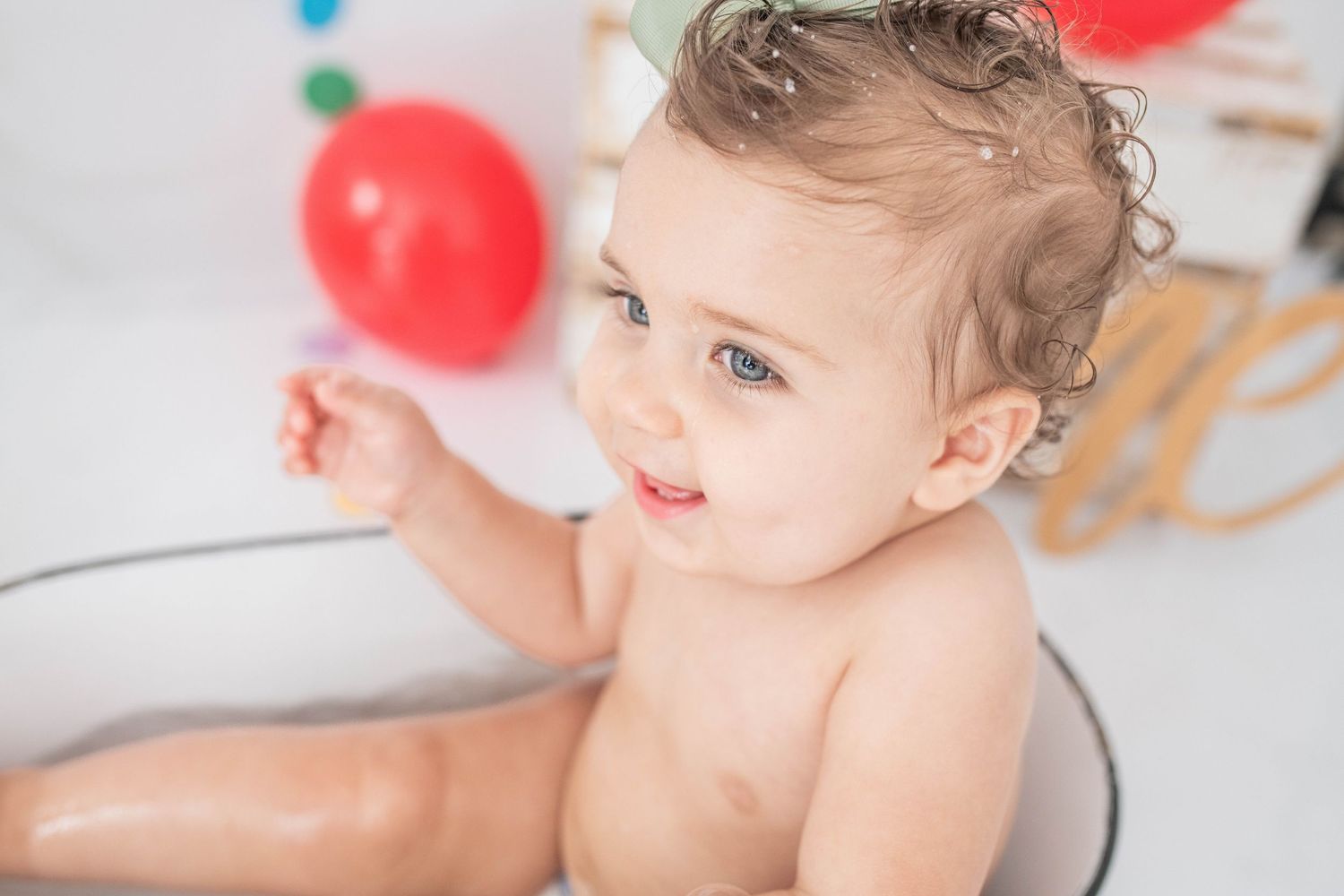 A happy baby celebrating her 1st year with a fun cake smash in the studio, capturing joyful moments and sweet memories!
