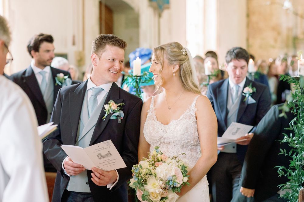 A church wedding ceremony with decorative floral bouquets and elegant formal attire.