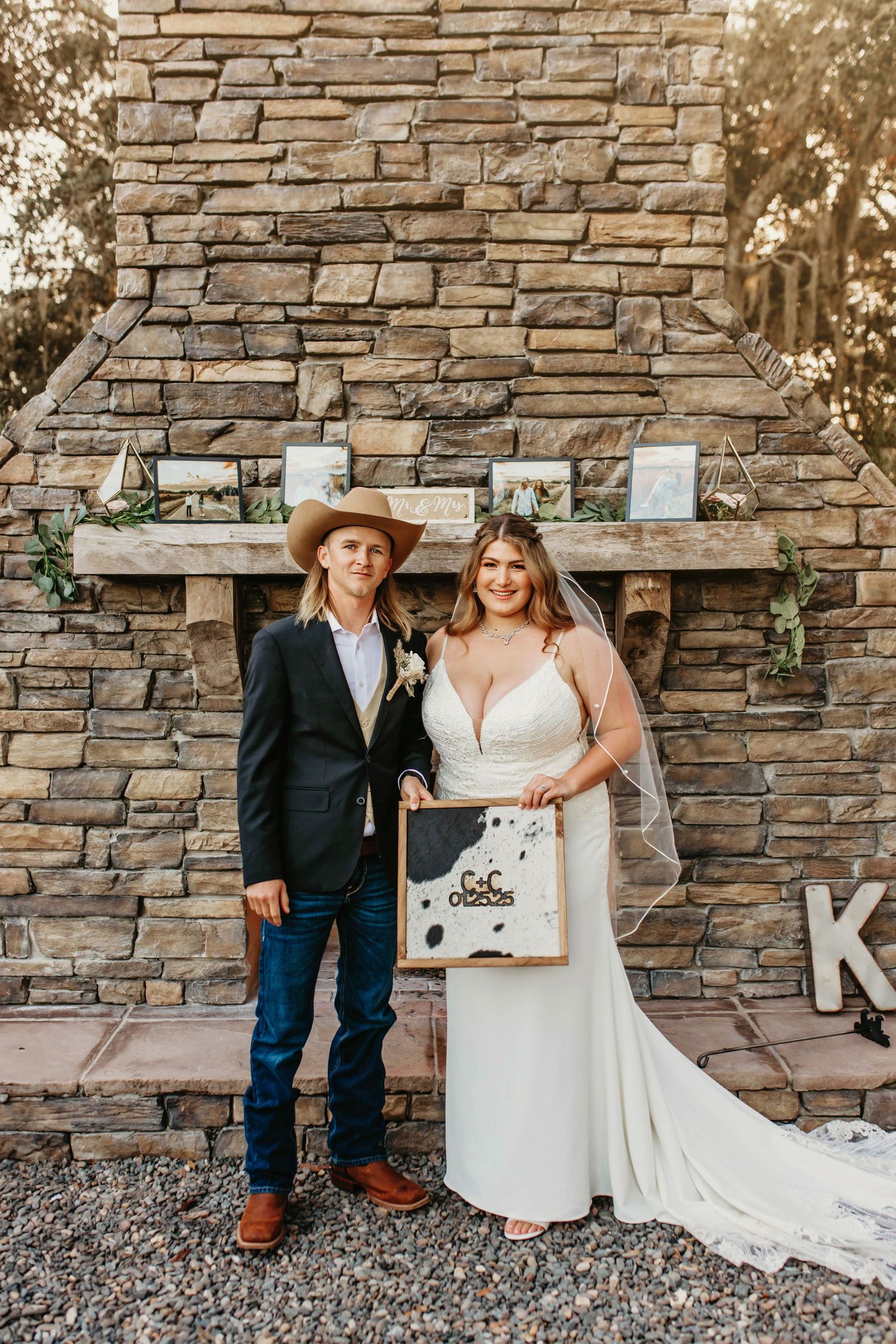 Western themed wedding portrait against stone fireplace with decorative sign.