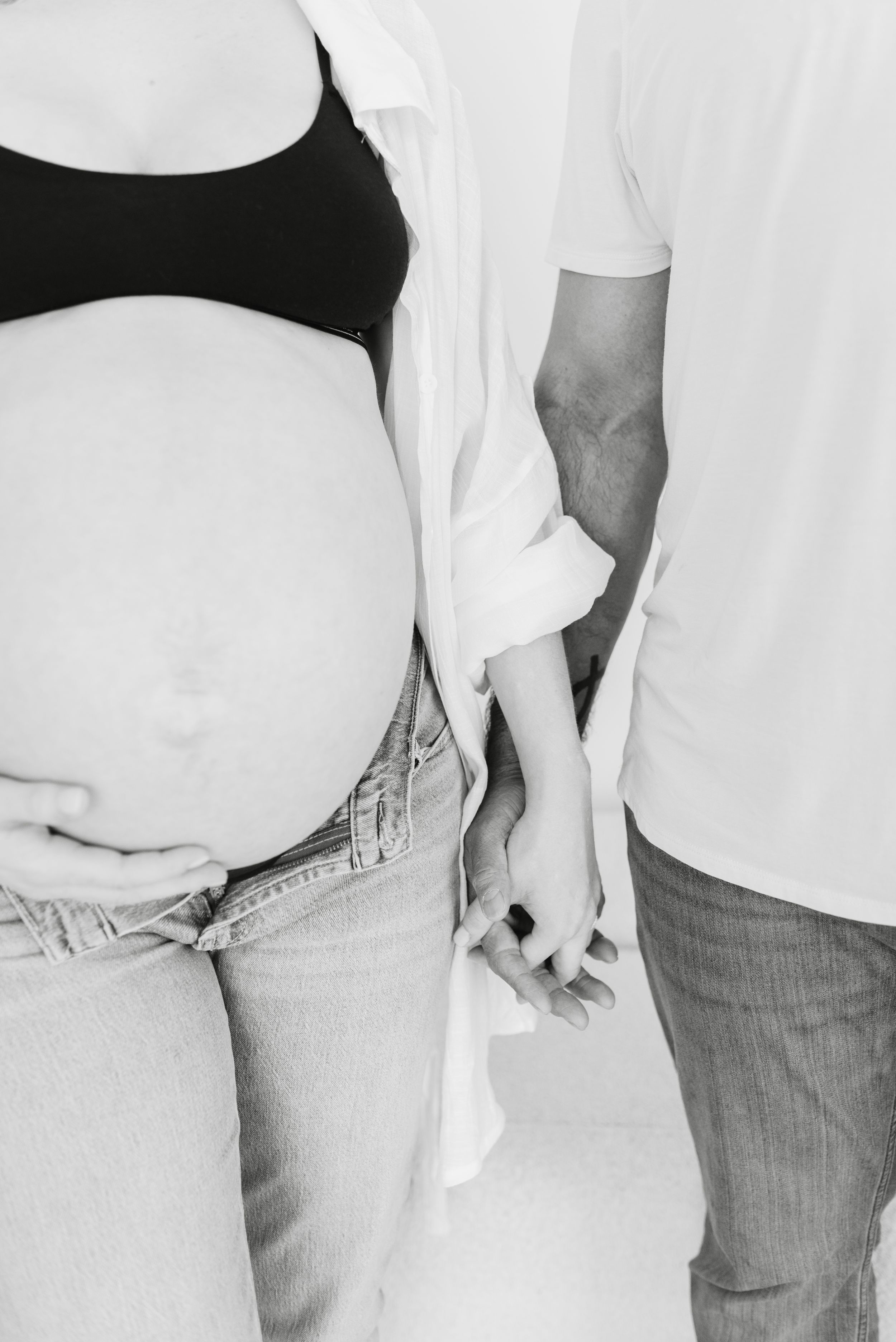 Toronto Mom holding hands with husband for maternity photoshoot at Mint Room Studio by Jess GC Photography