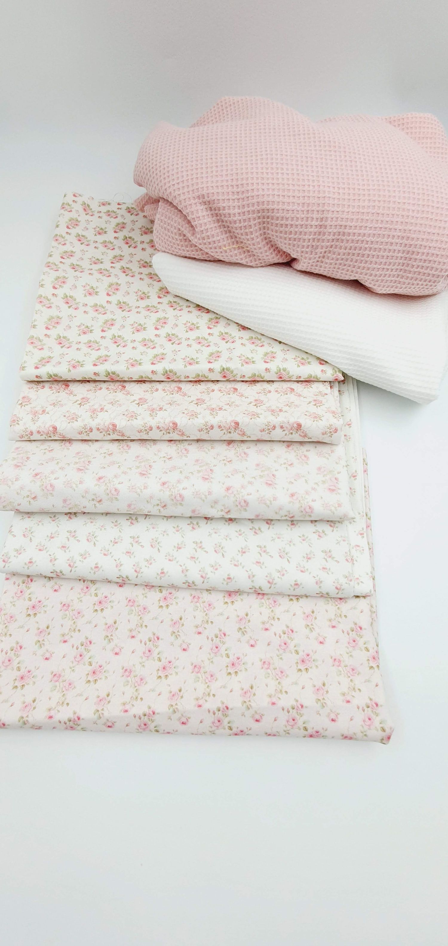 Pink and white floral patterned bedding set with a waffle textured pillow displayed on a light background.