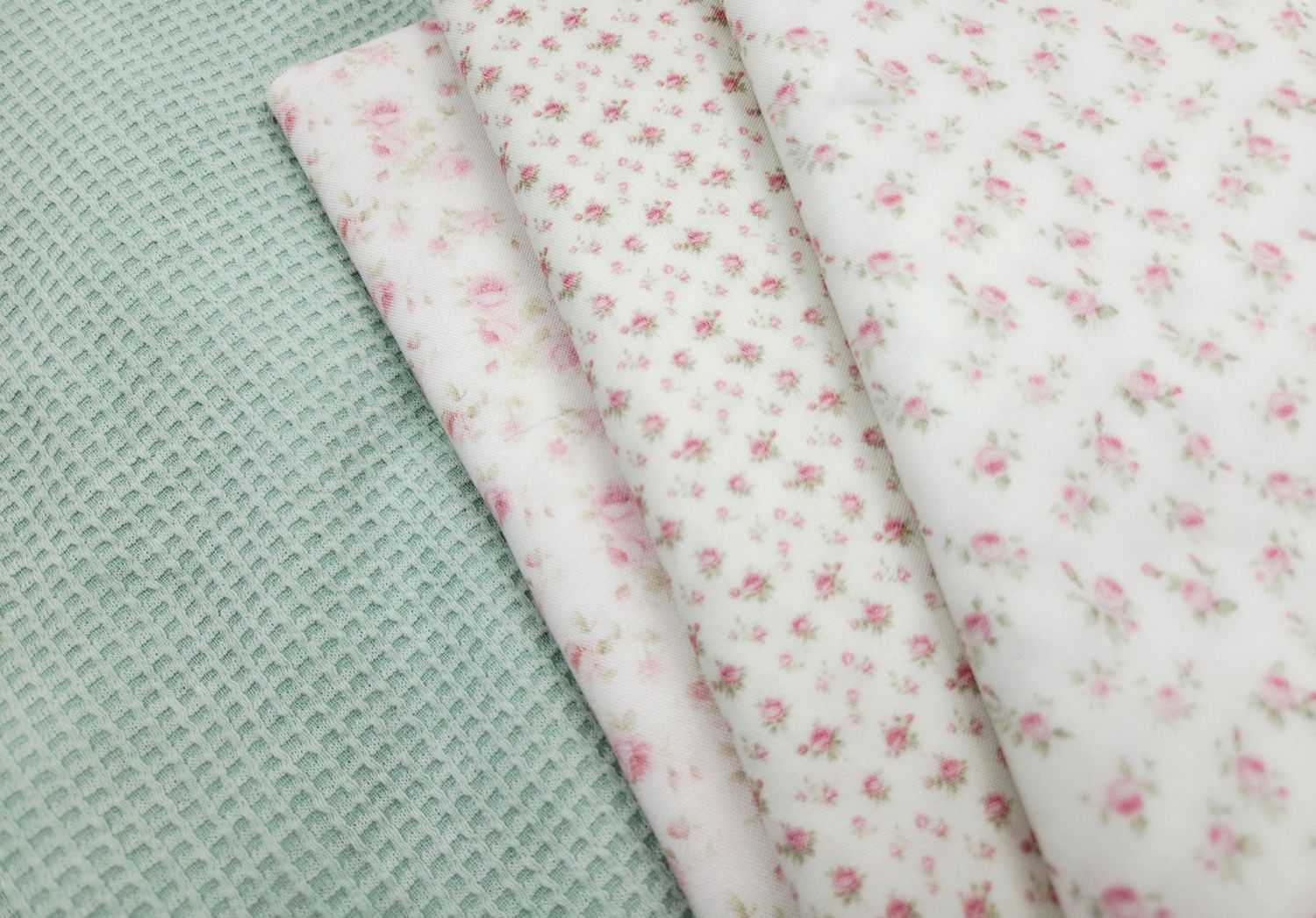 Delicate pink floral pattern fabric swatches in vintage style arranged in diagonal rows on mint green background.