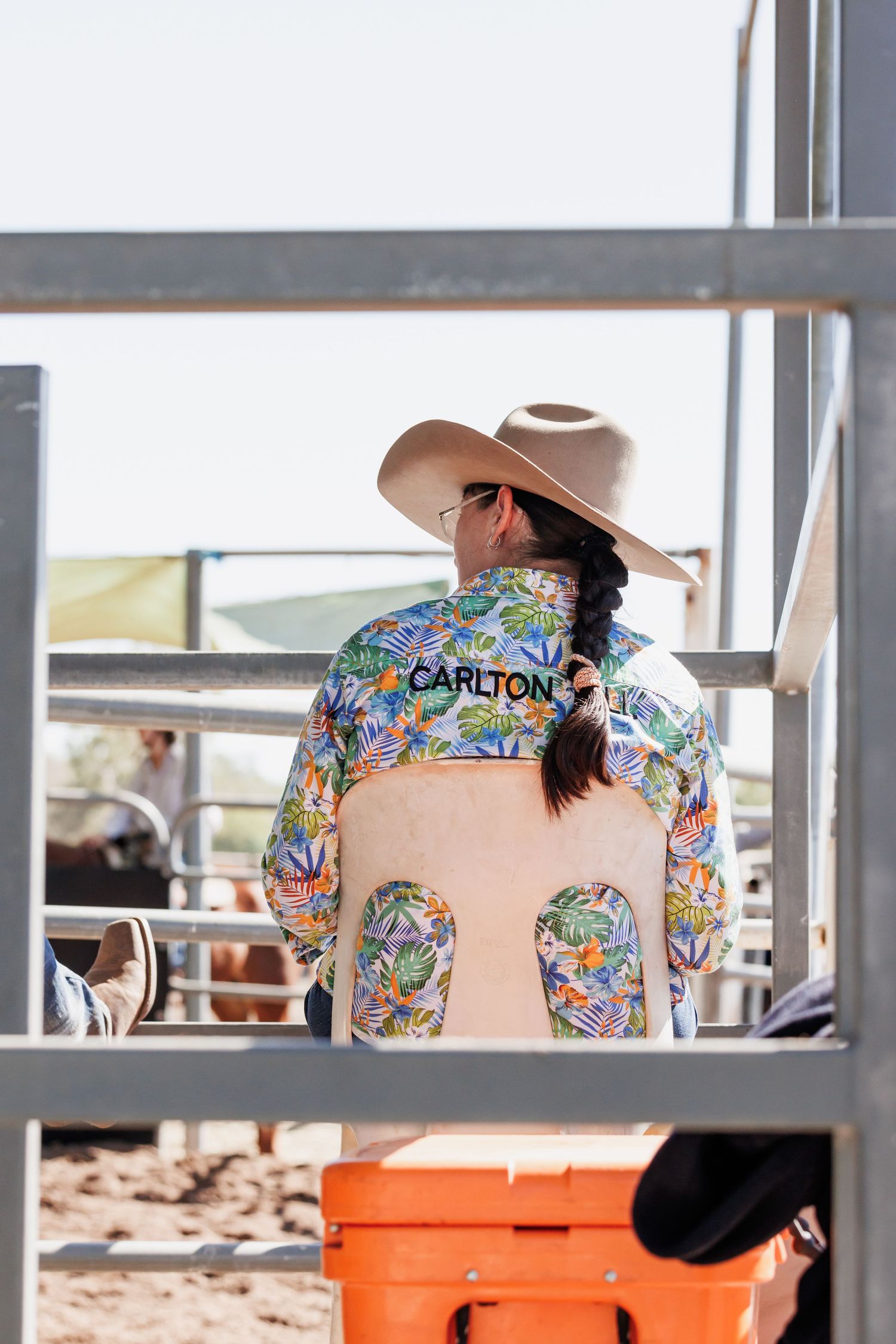 Colorful western shirt with Carlton text seen from behind at a rodeo.