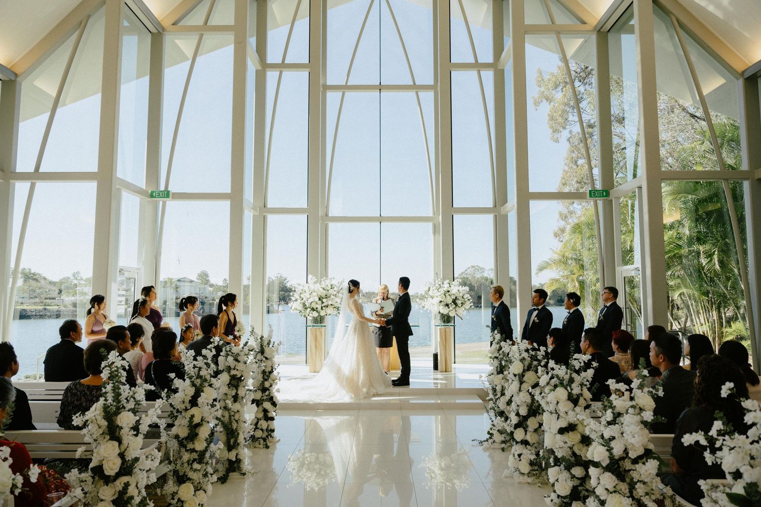 "Elegant wedding ceremony at InterContinental Sanctuary Cove Resort with natural light and glass venue