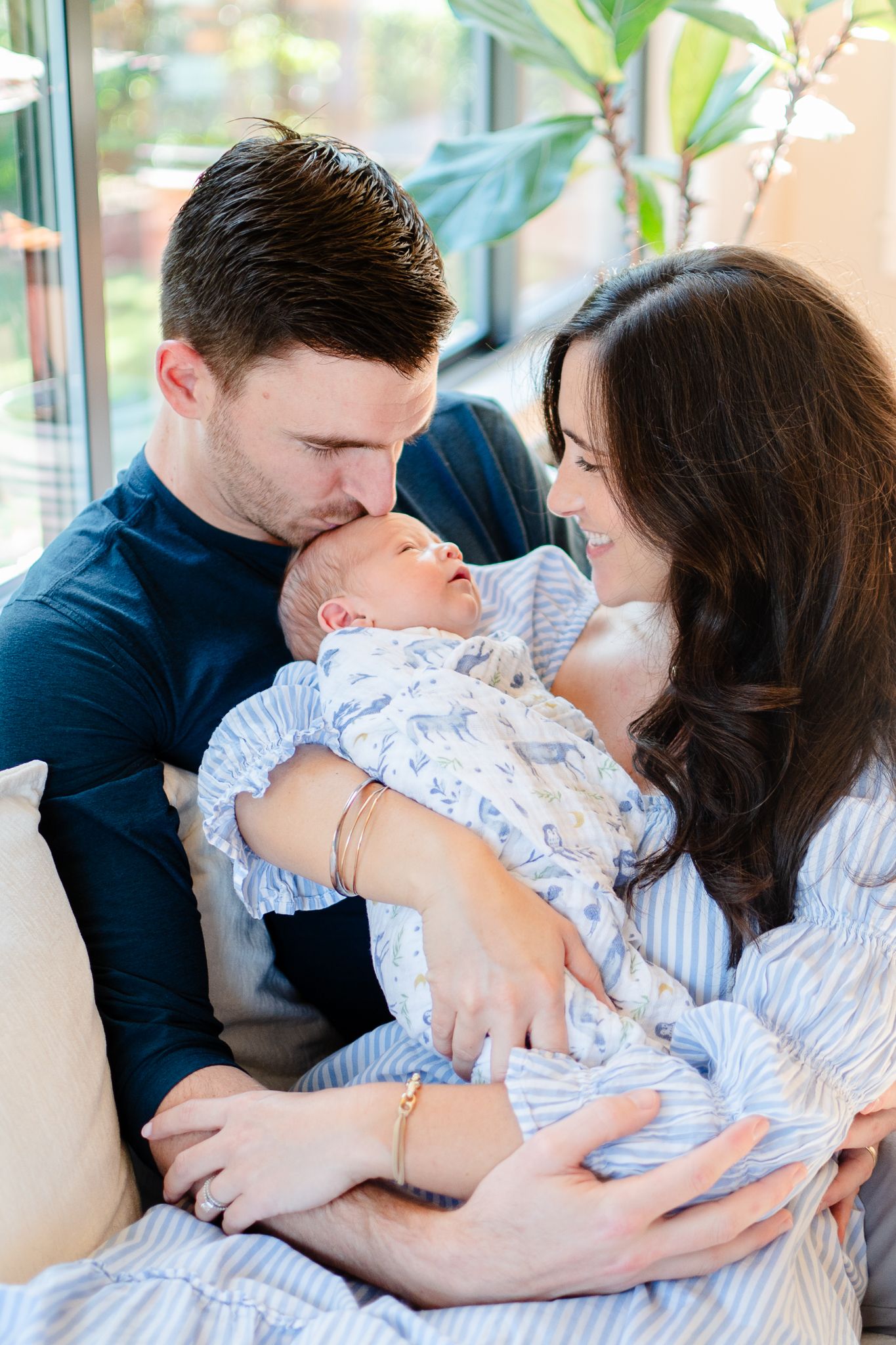 Dad kisses baby's head as the family indulges in sweet newborn cuddles in their Winston-Salem home.