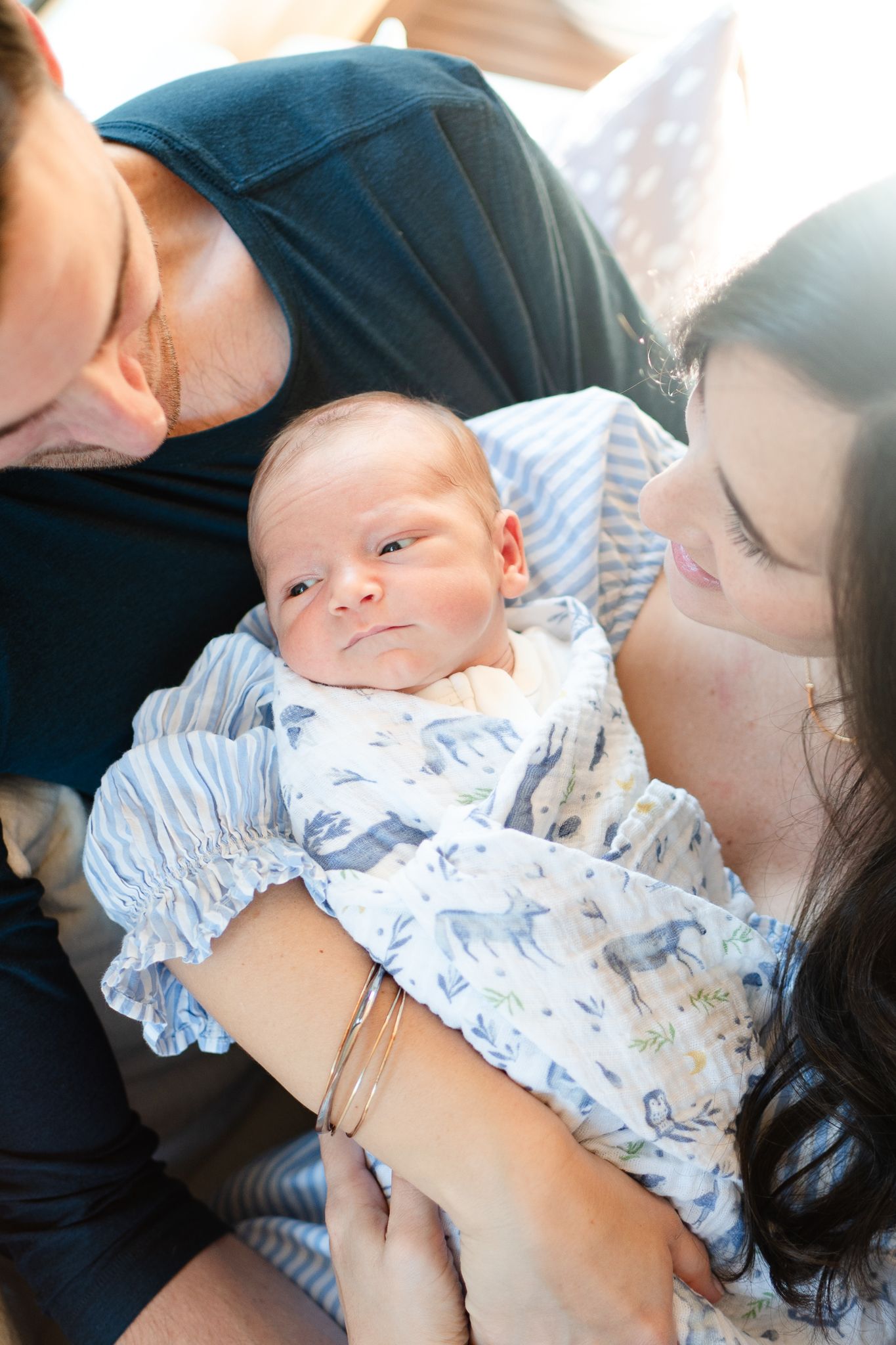 Family holds their newborn during their in-home newborn session.