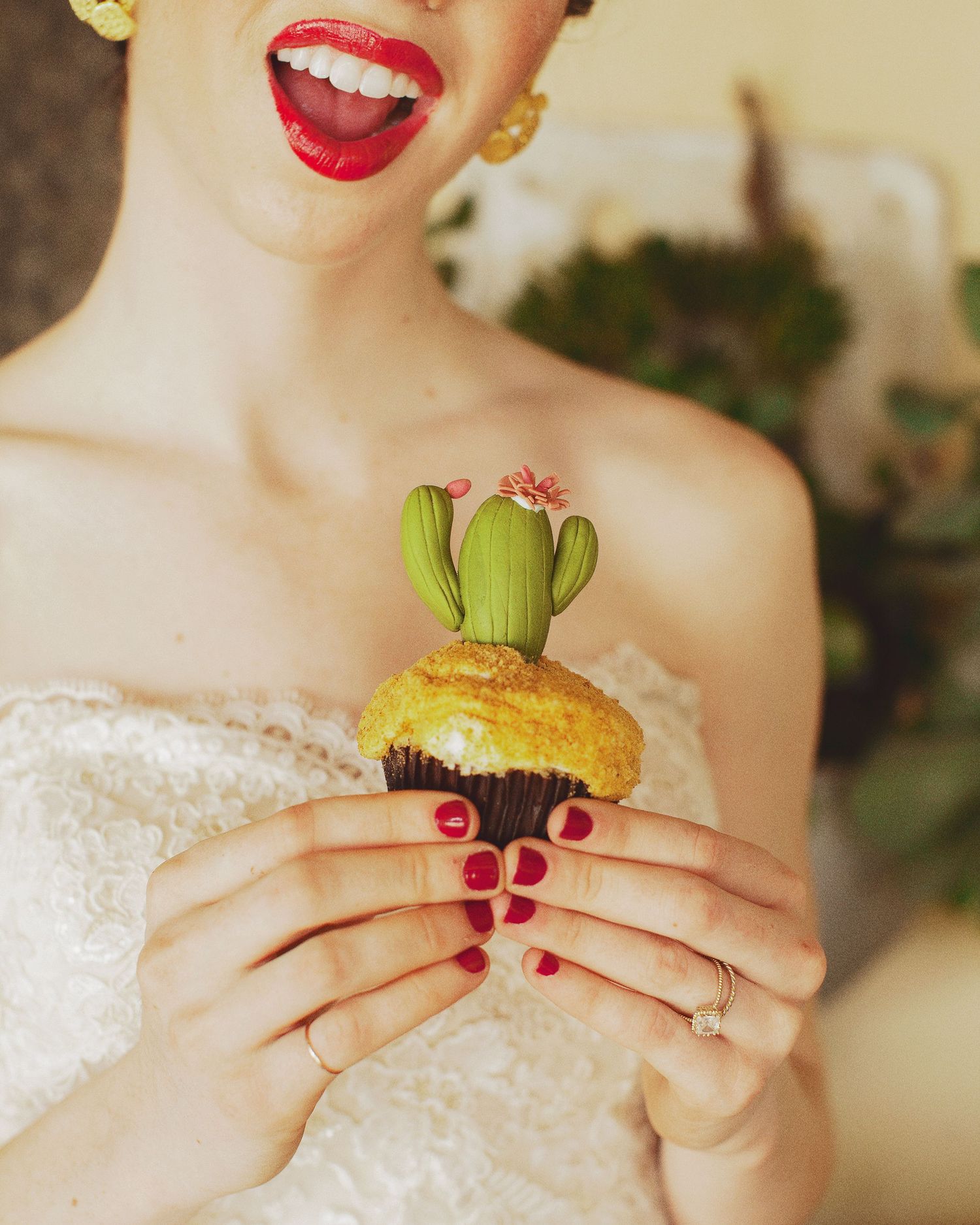 Fun wedding detail shot featuring bright red lips and a cute cactus-topped cupcake.
