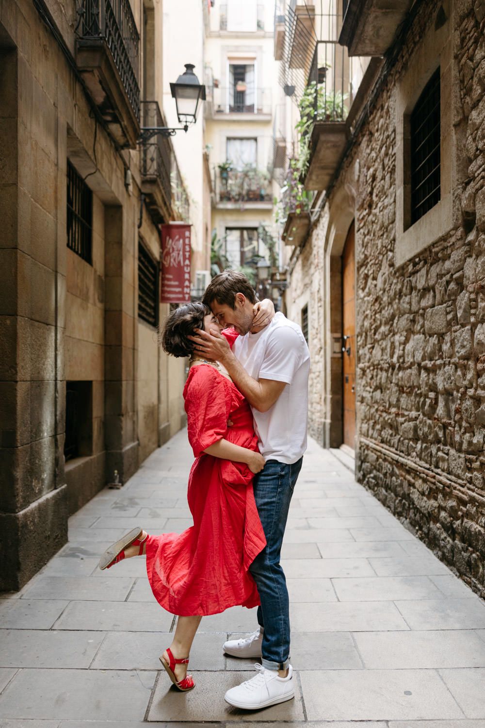 A romantic couple dancing in a narrow cobblestone alley of Barcelona's Gothic Quarter.