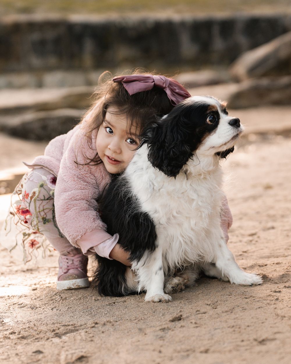 A little girl cuddling her puppy during a family photoshoot in Sydney