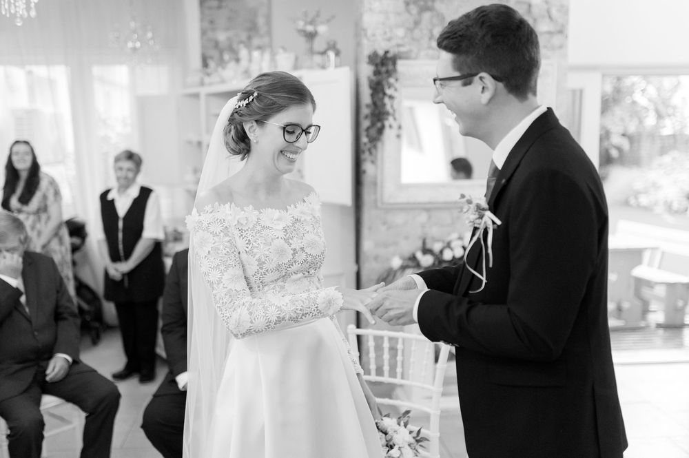 Black and white photo of bride and groom exchanging vows during intimate wedding ceremony.