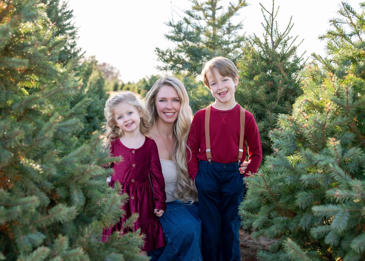 Mother and her 2 young children standing in a row of evergreen trees. Wrightstown NJ Family Photographer