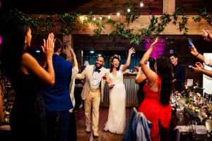 Bride and groom make a grand entrance at their rustic barn wedding reception.