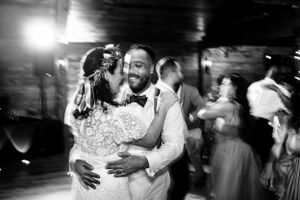 Black and white photo of bride and groom sharing emotional dance at wedding reception.