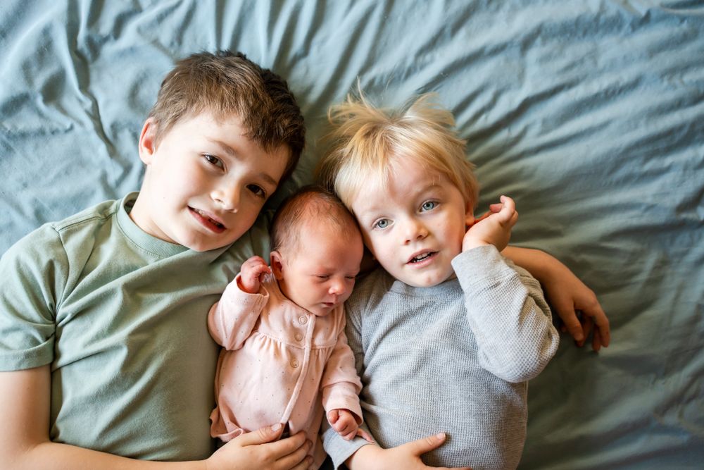 big brother's cuddle with newborn daughter