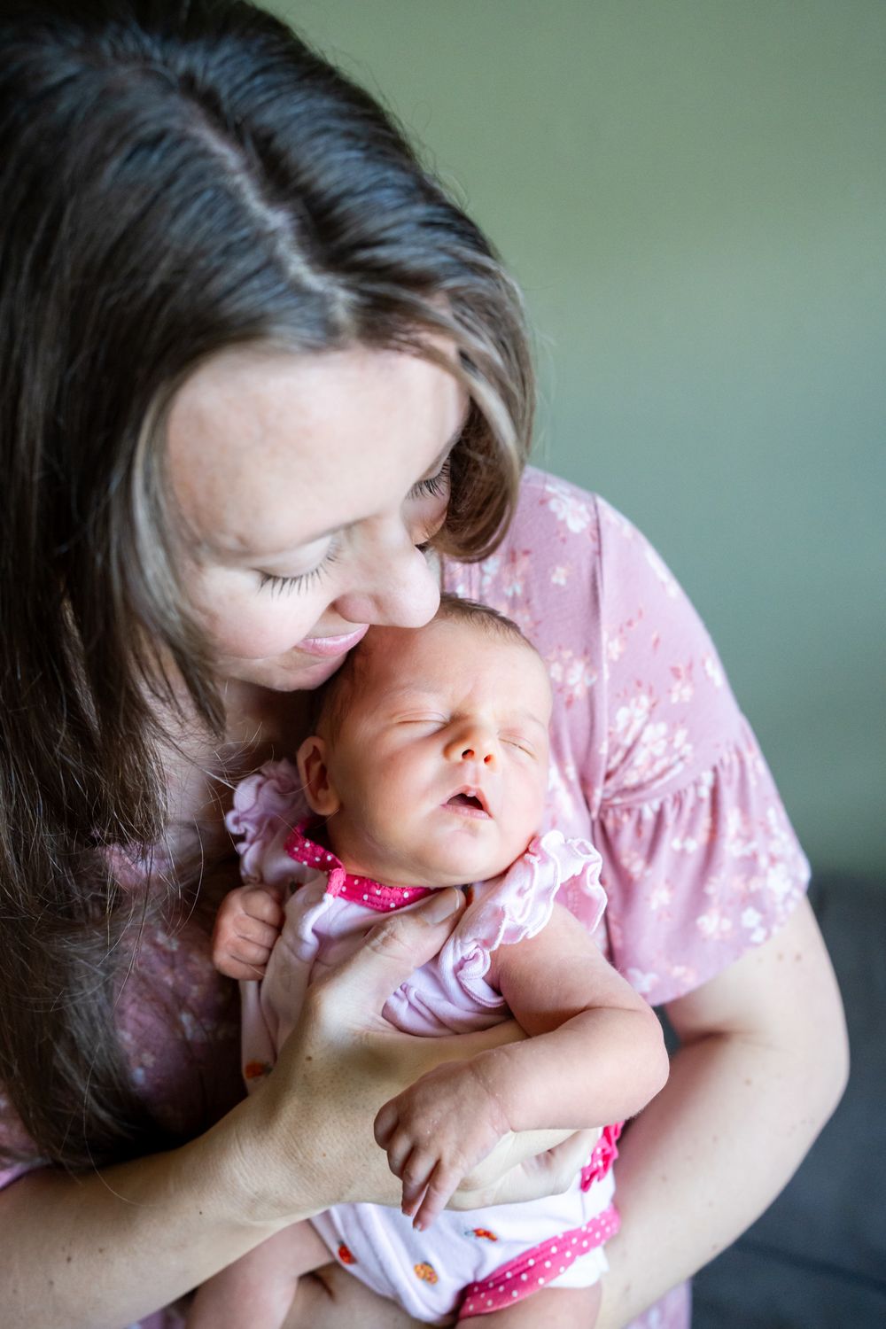 mom holds and looks down at newborn daughter
