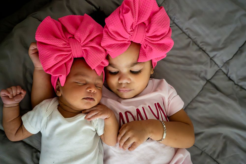 sisters with matching ethnic bows cuddle together