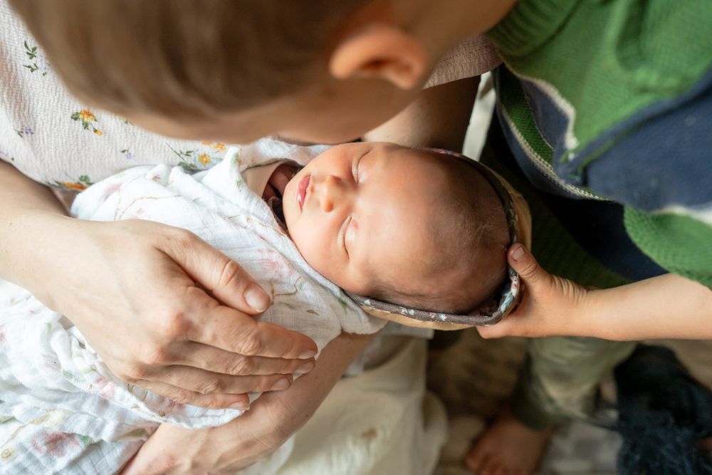 big brother looks at newborn sister