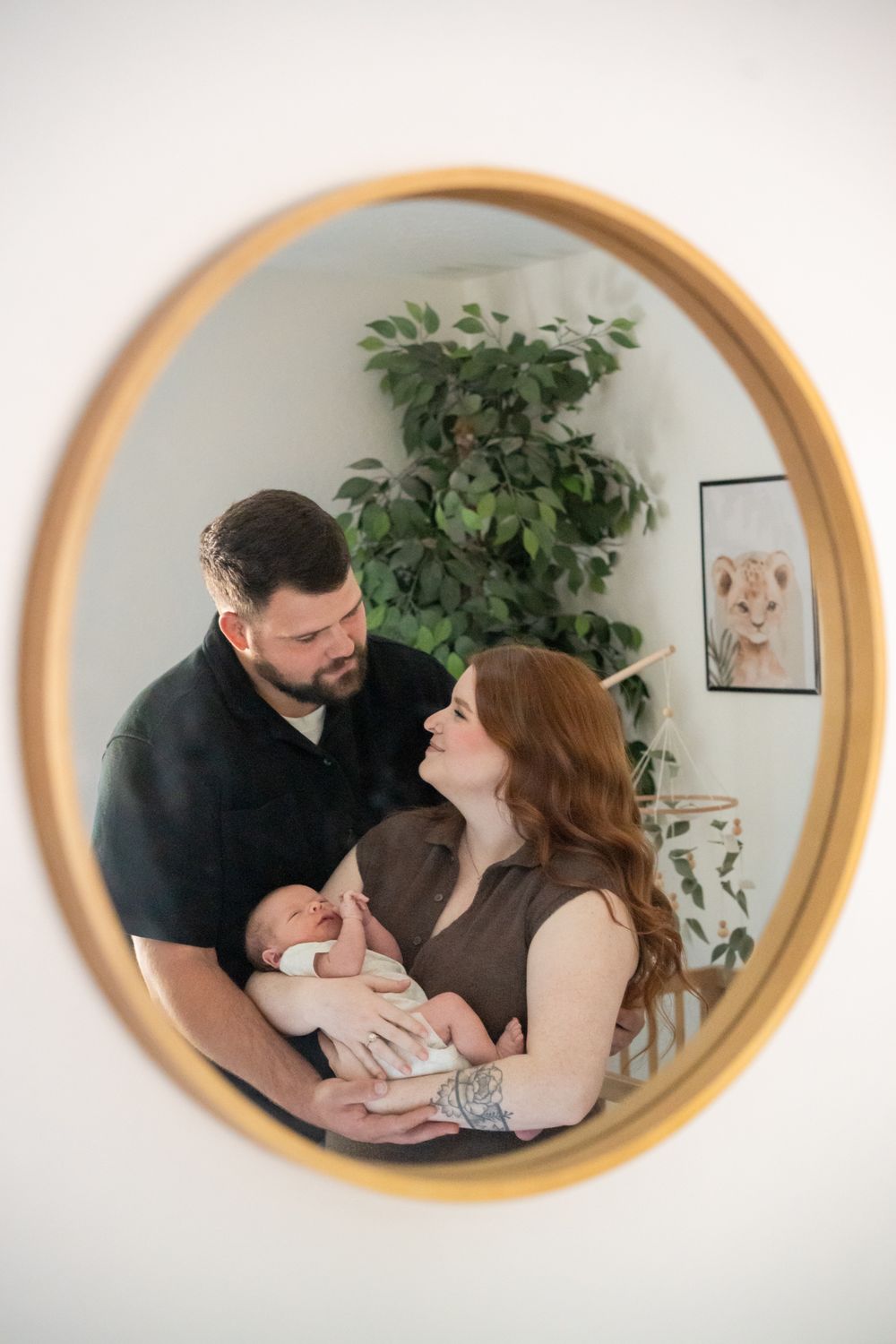 Newborn family portrait in a reflection of a mirror in the baby's nursery