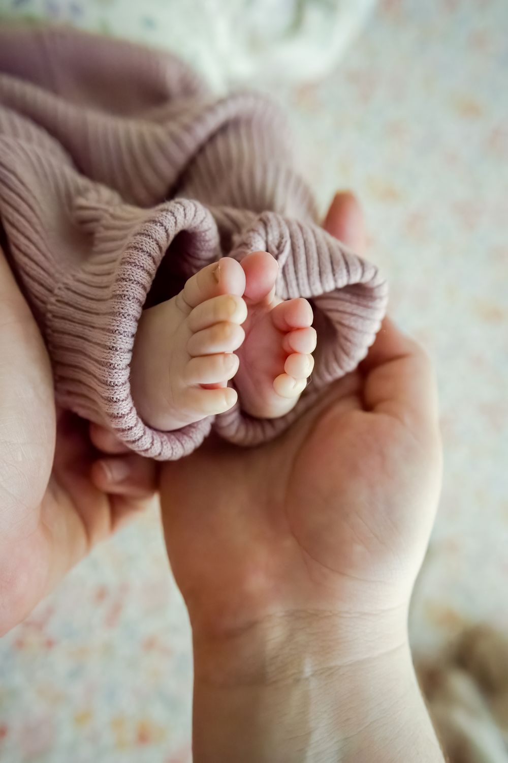 mom holds baby girl's feet