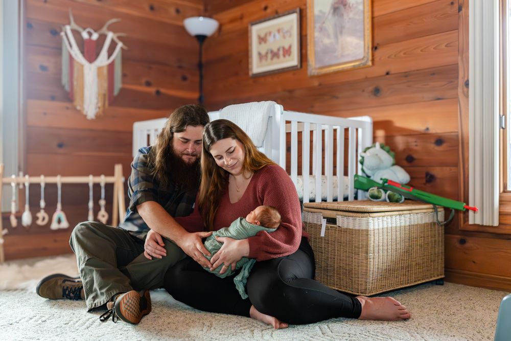 mom and dad hold newborn daughter in the nursery at home
