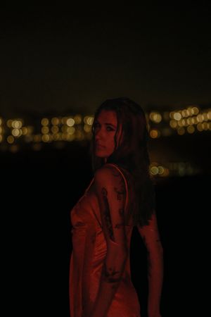 Model posed at night on beach in a red dress