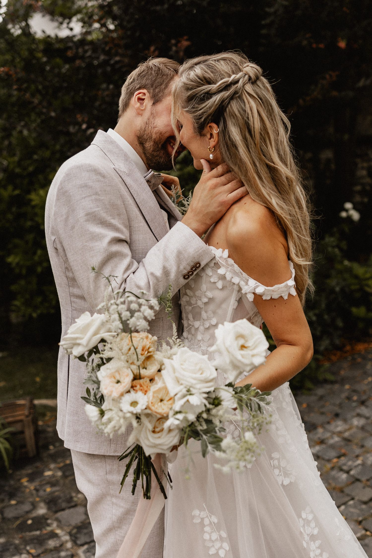Intimate wedding portraits with white floral bouquet and light colored attire.