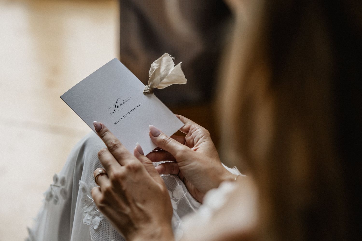 Hands holding a handwritten letter or note in soft natural lighting.