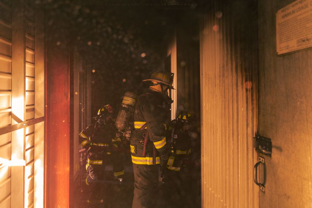 Firefighters work inside a smoke-filled building during an active fire response.