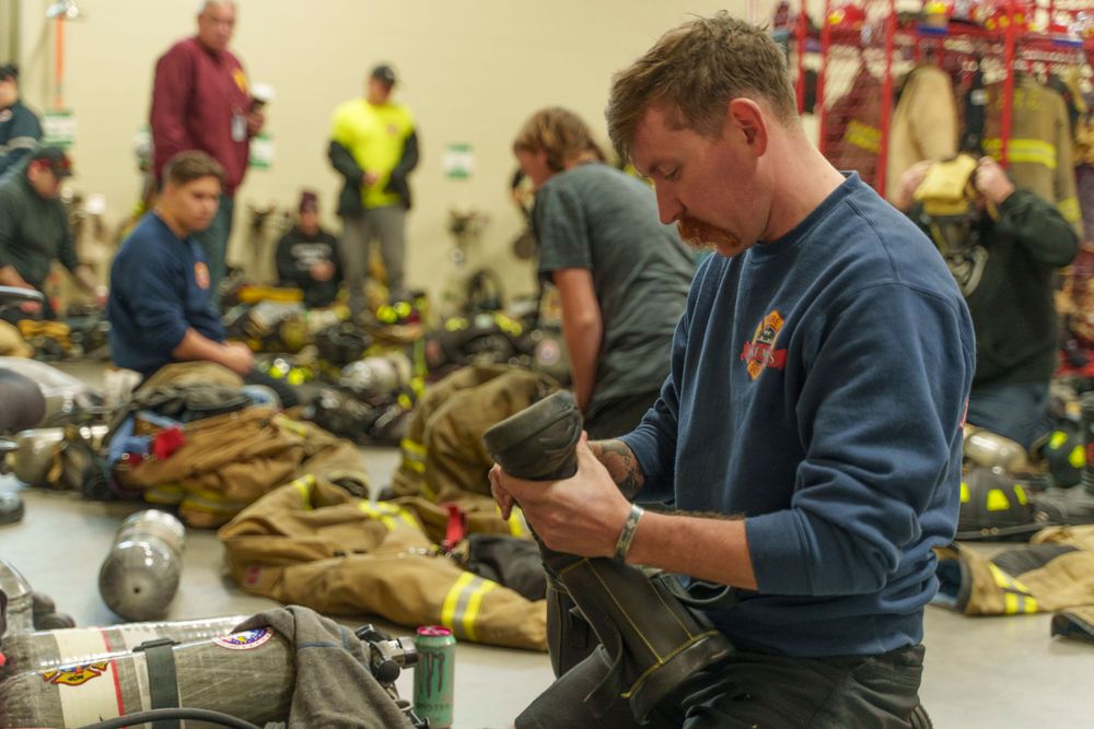 Emergency responders preparing equipment in indoor facility.