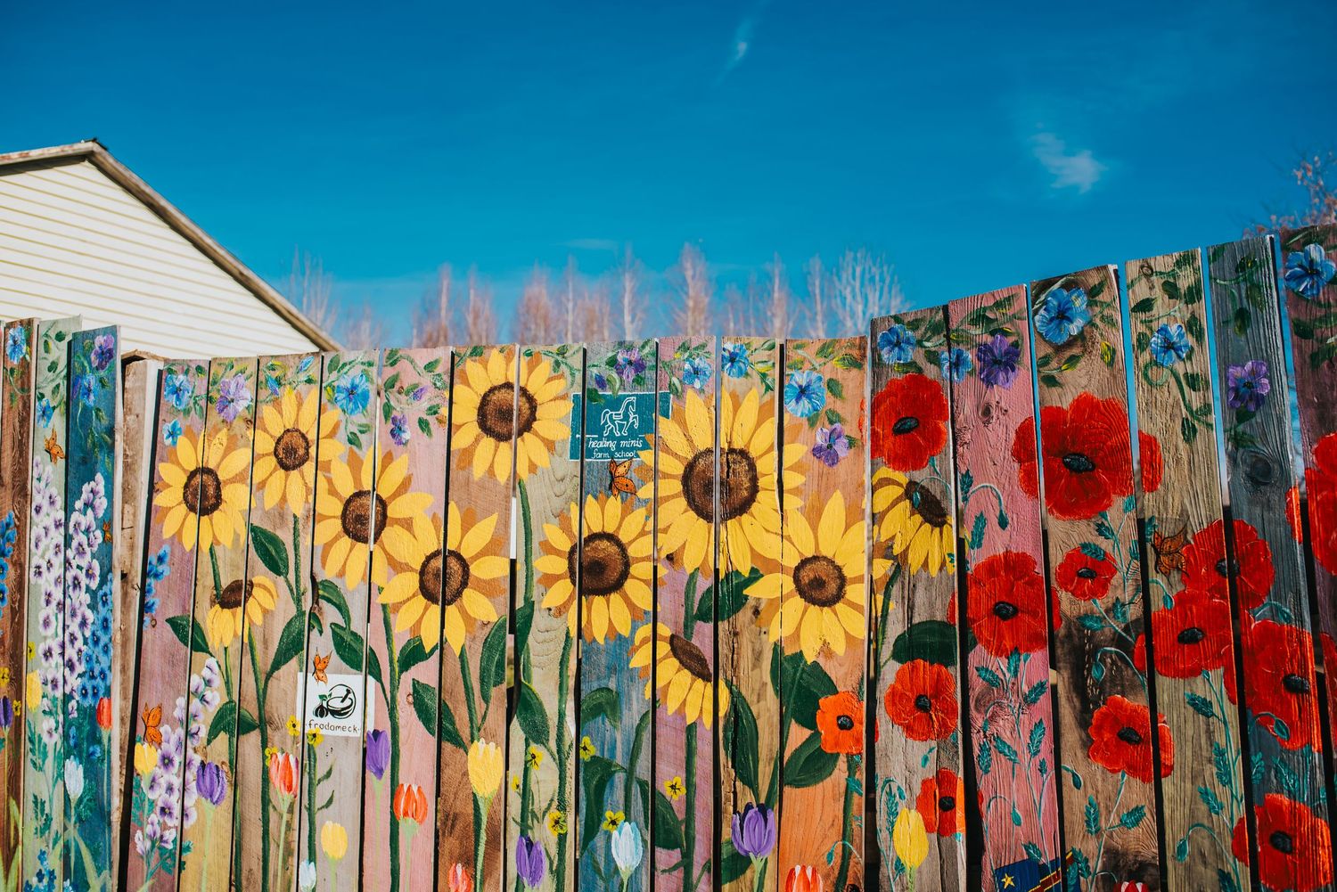 Beautiful painted fence with flowers and flags.