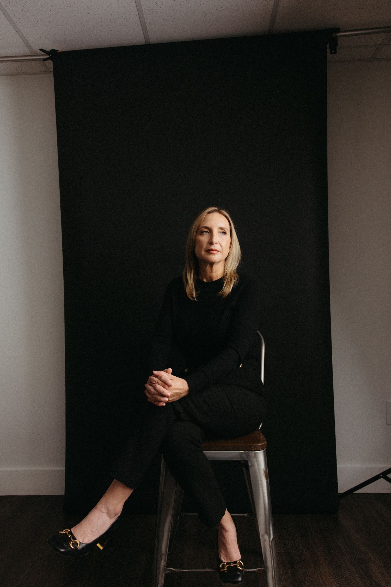 Moody studio portraits against black backdrop with dramatic lighting.
