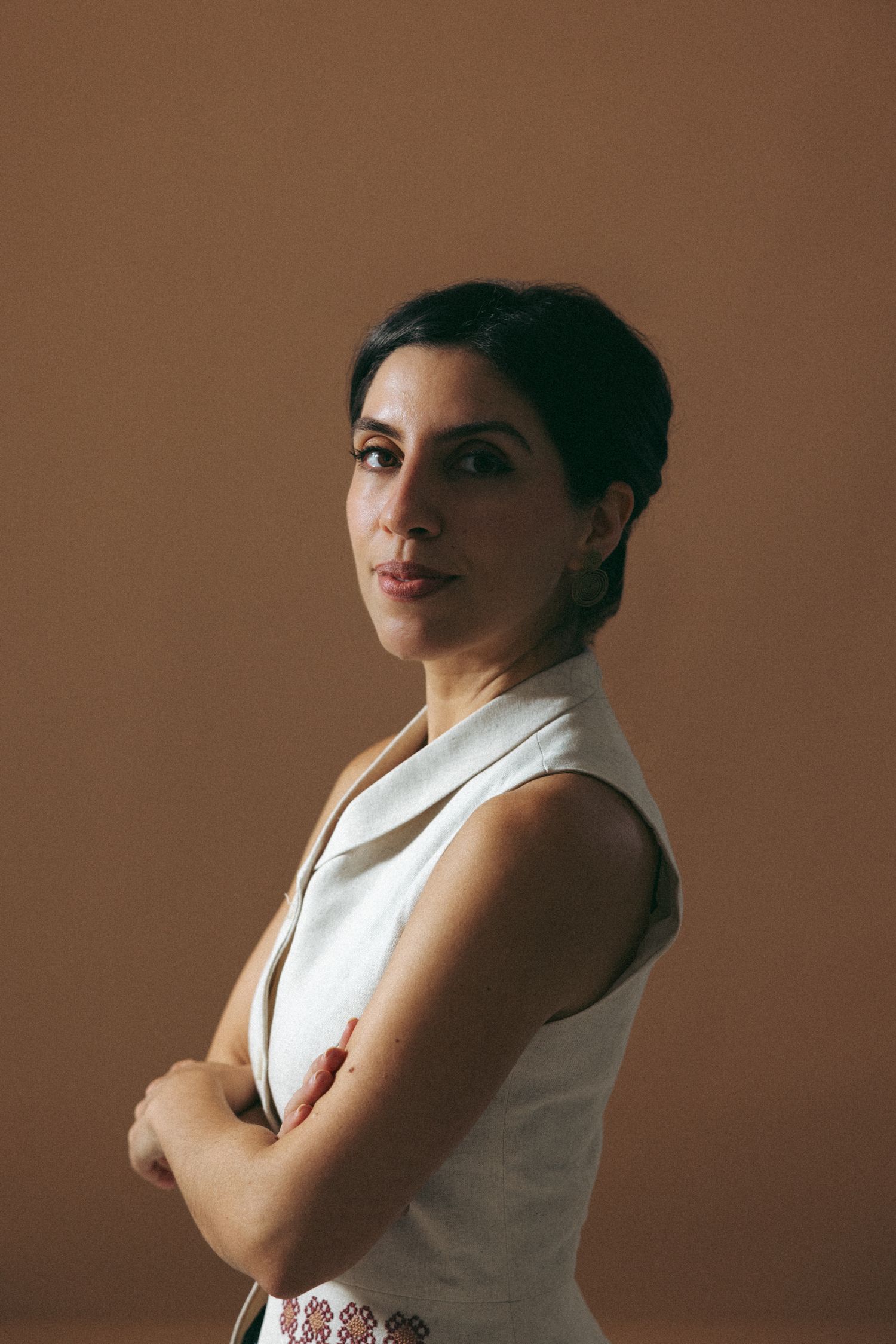 A series of artistic portrait photos showing a person in a white sleeveless top against a brown background.