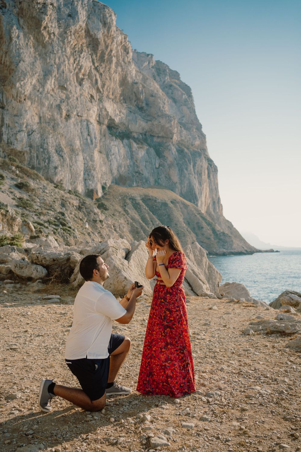 Man on one knee proposing in Sicily, in Capo Gallo nature reserve.