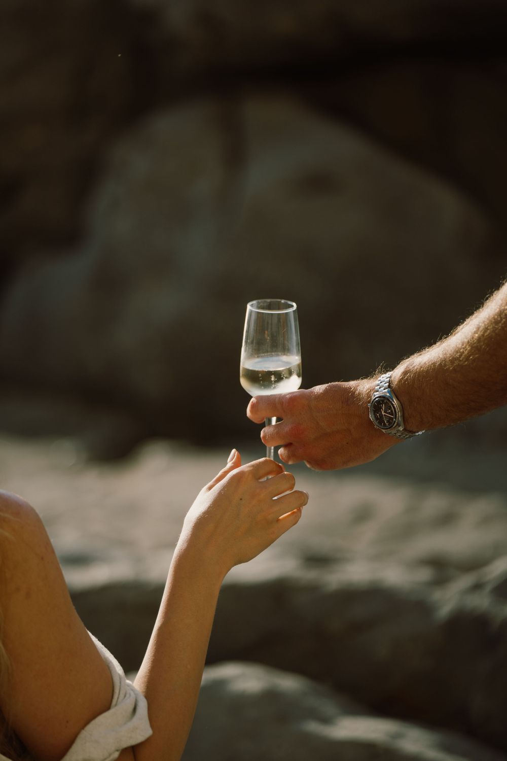 Newly engaged couple celebrating with a glass of champagne in Cefalù, Sicily