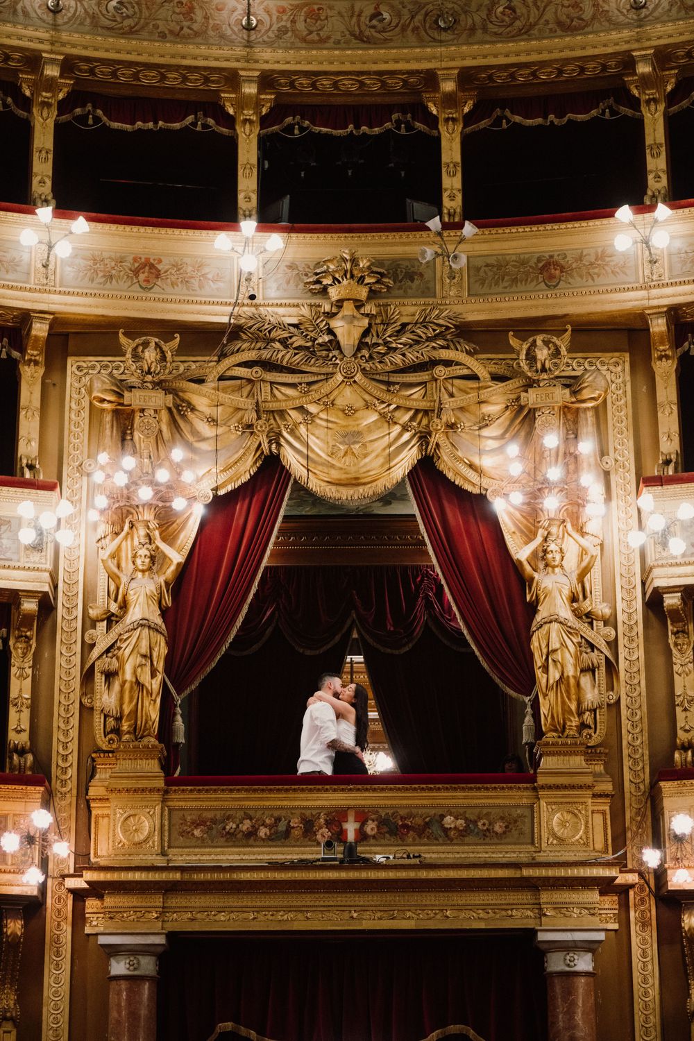 Couple hugging after a surprise proposal in Teatro Massimo in Palermo, Sicily