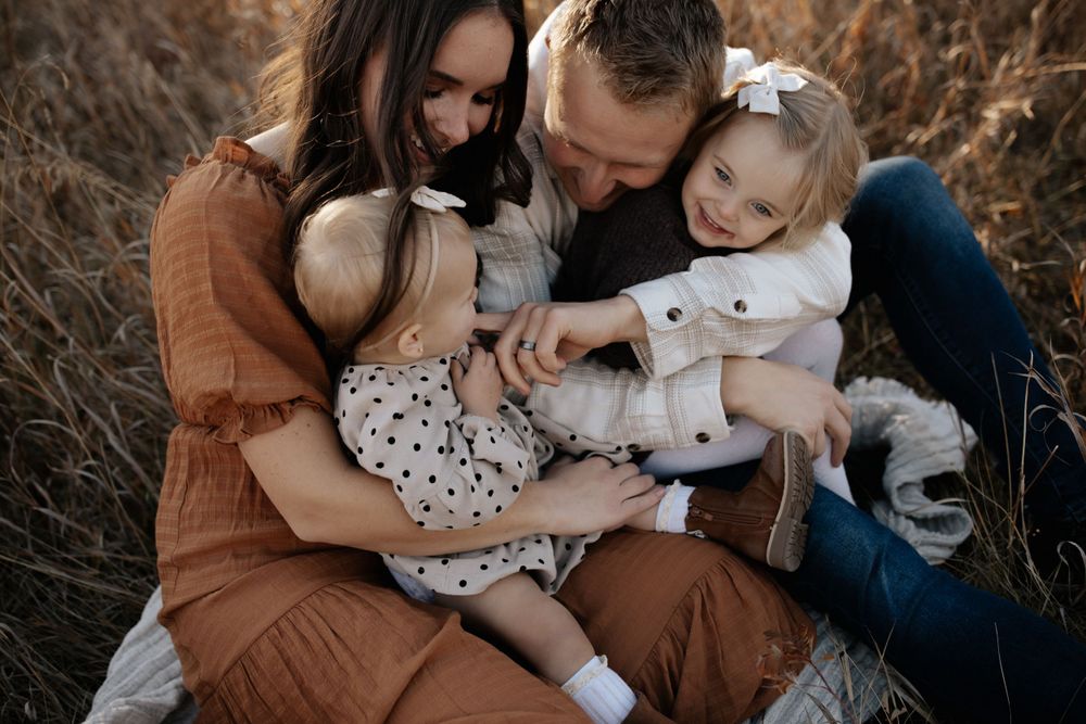 Intimate family photography session in a natural outdoor setting with warm autumn colors.