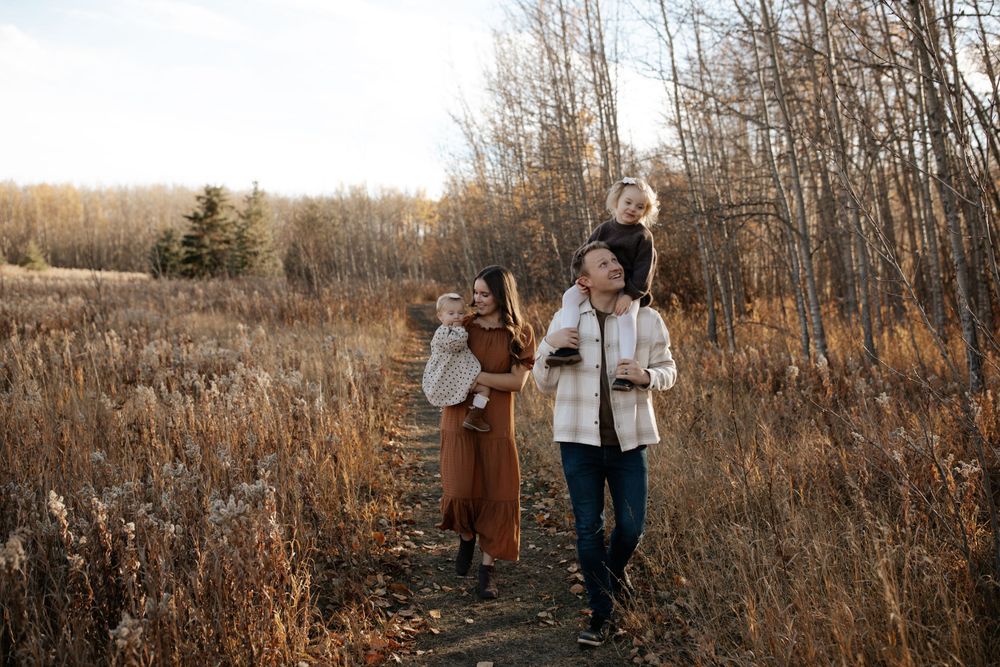 Family portrait session in a rustic field setting during golden hour.