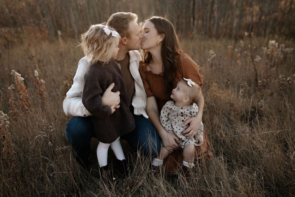 Intimate family moments captured in warm natural light among tall grass.