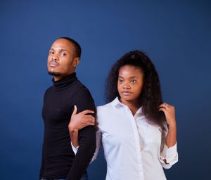 Two people in contrasting white and black outfits pose for a romantic photo session.