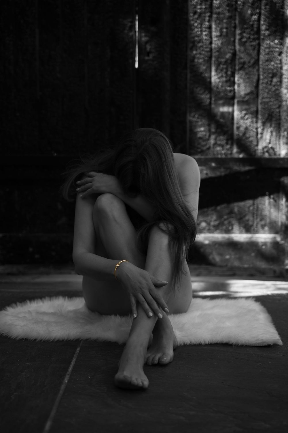 Black and white artistic photo series showing a person lying on a white rug in dramatic shadows.