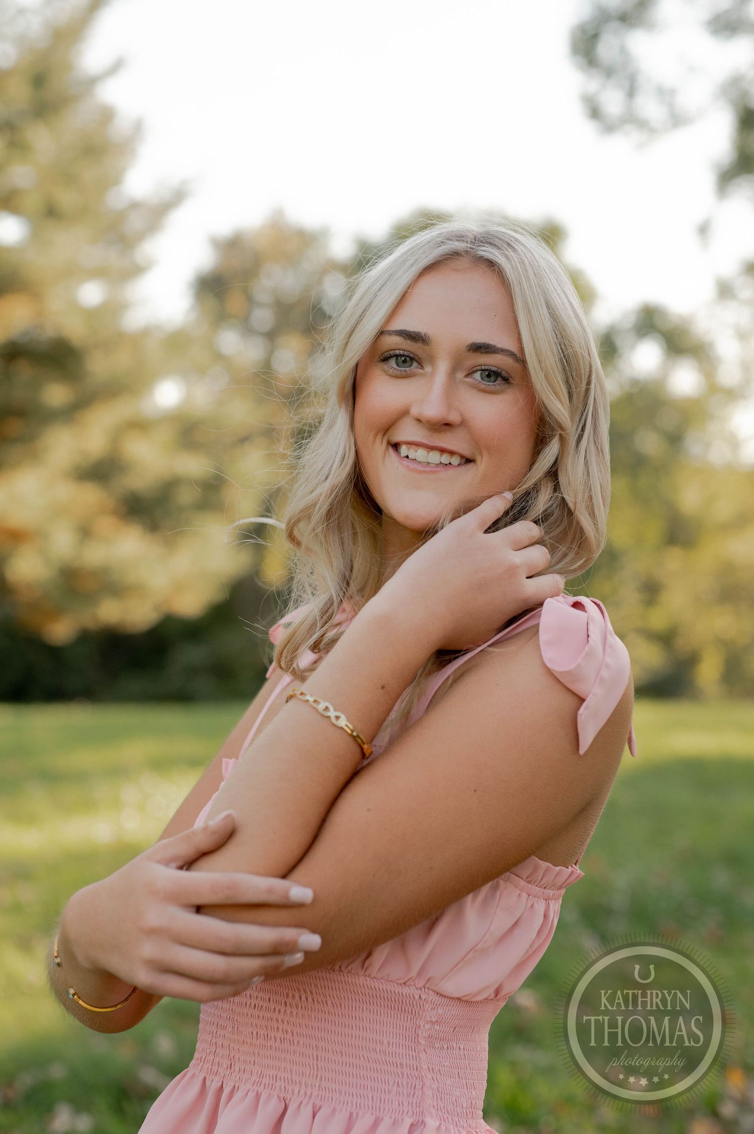 A summery portrait featuring a pink smocked top and natural outdoor lighting.