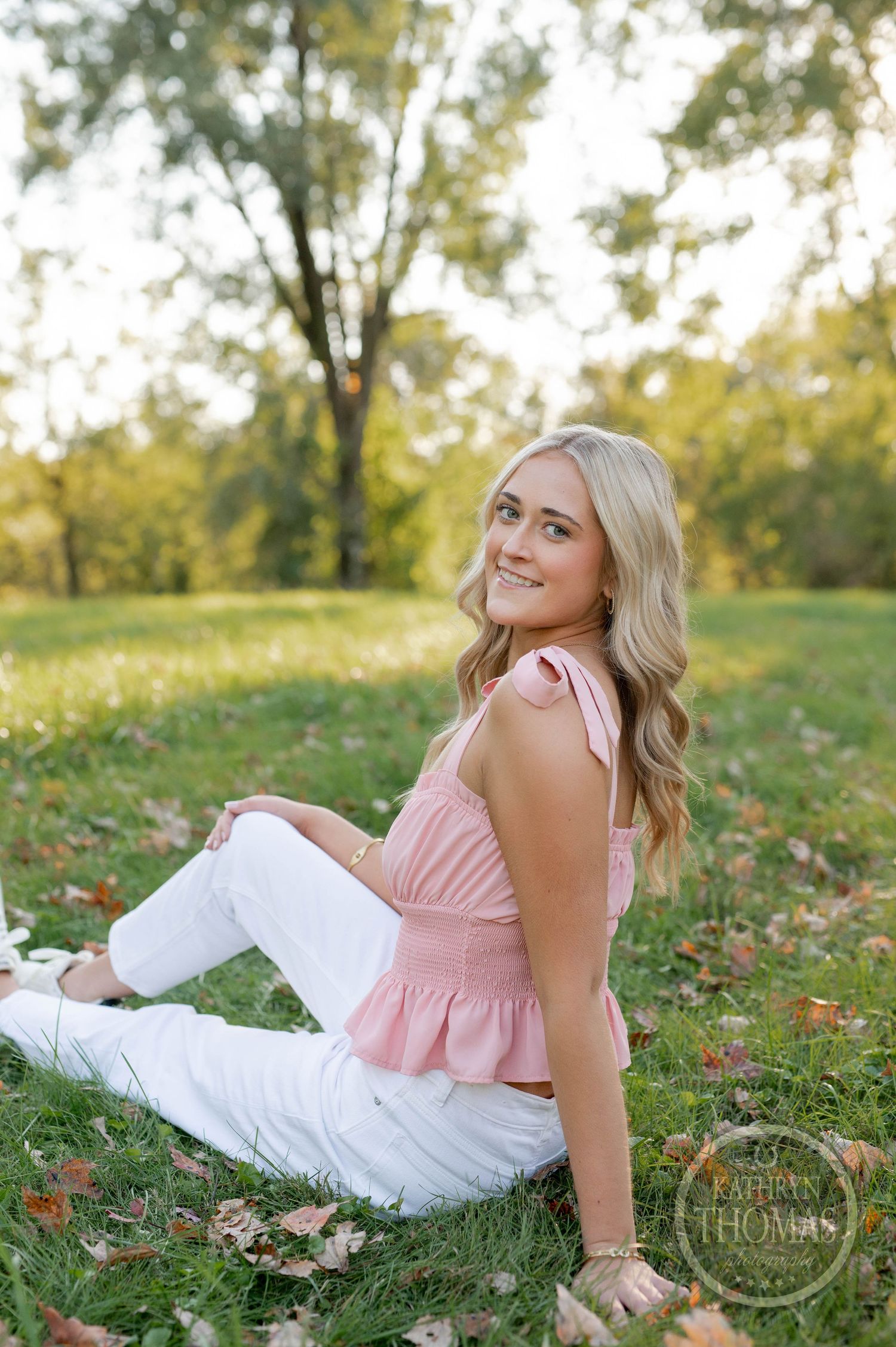 Casual outdoor portrait with pink peplum top against golden evening light.