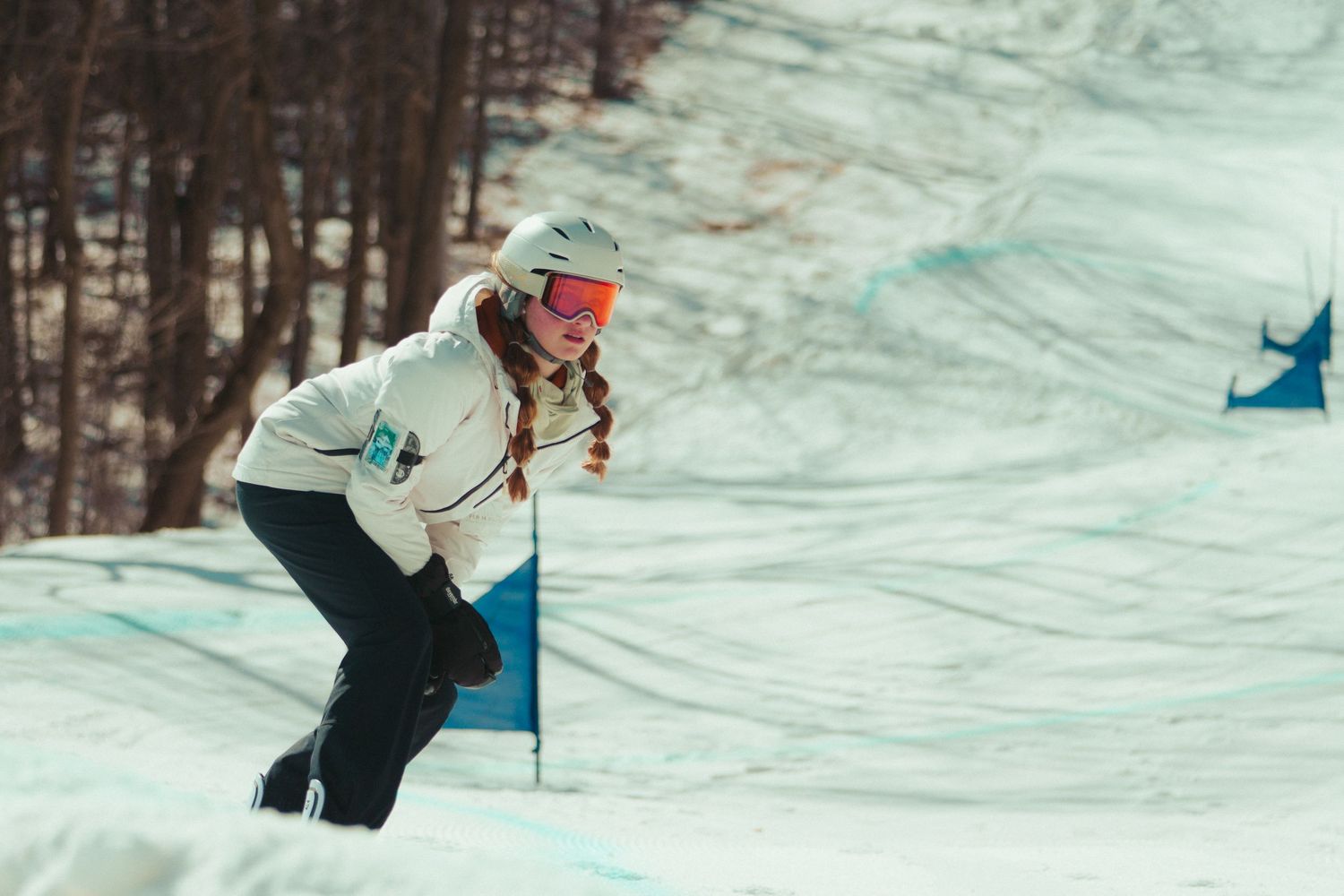 snowboarder navigates downhill course on snowy winter slope.