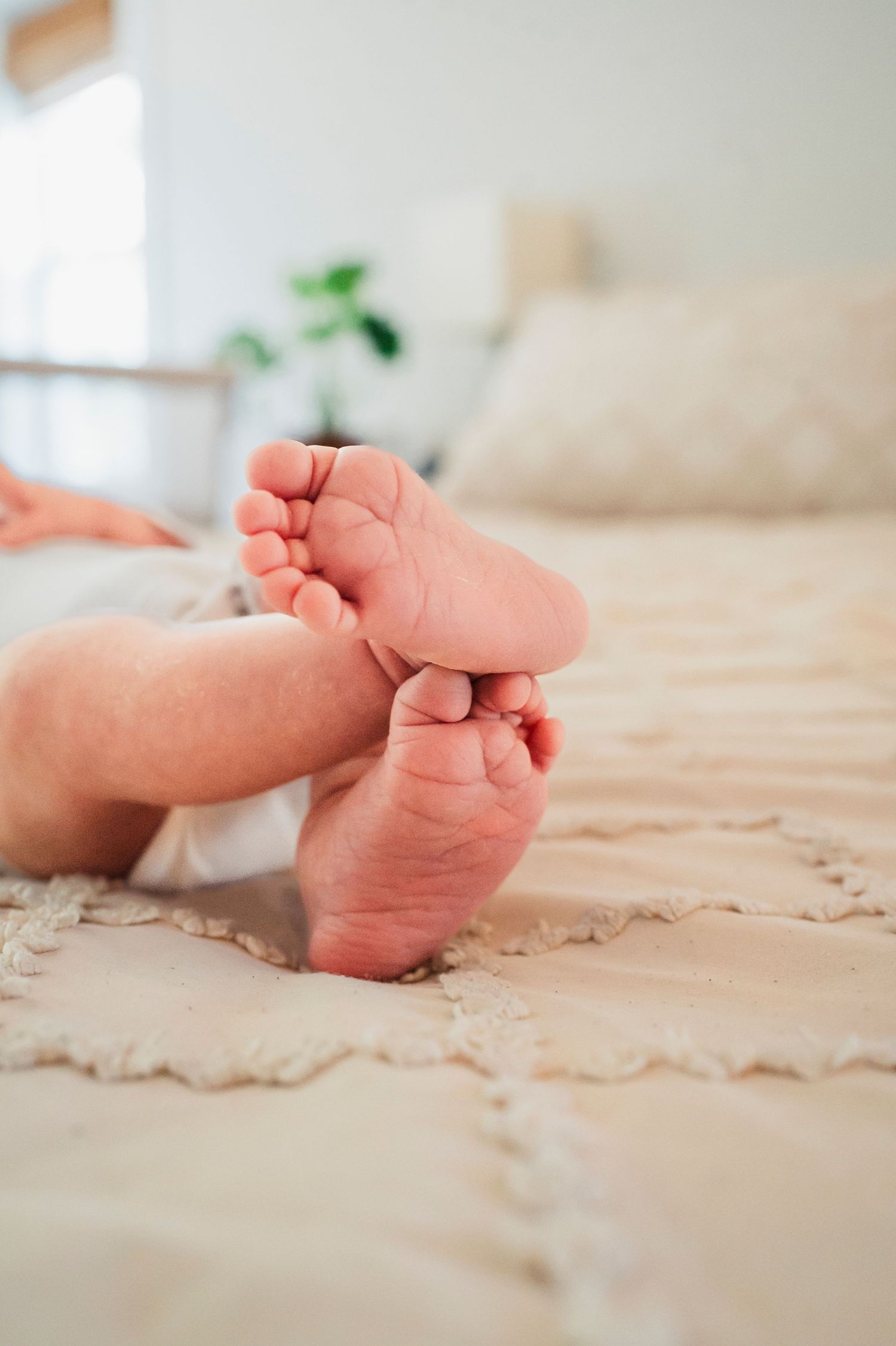 Close-up photo series showing tiny baby feet on cream-colored textured bedding.