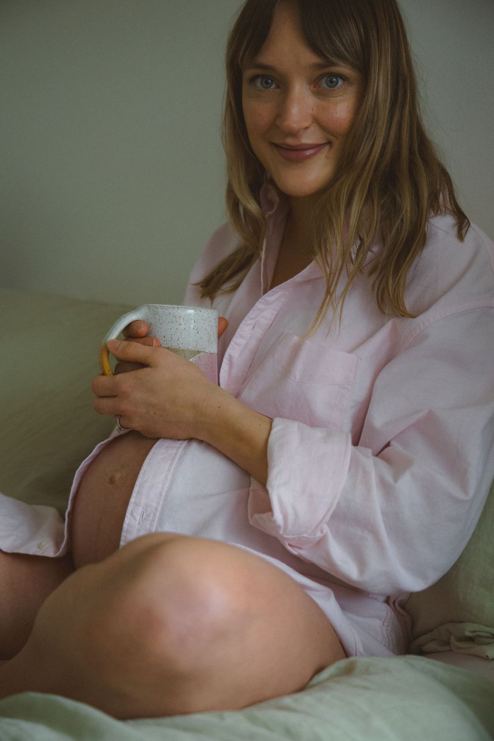 expecting mom holding her coffee mug on her growing baby bump during a maternity session in vancouver, bc.