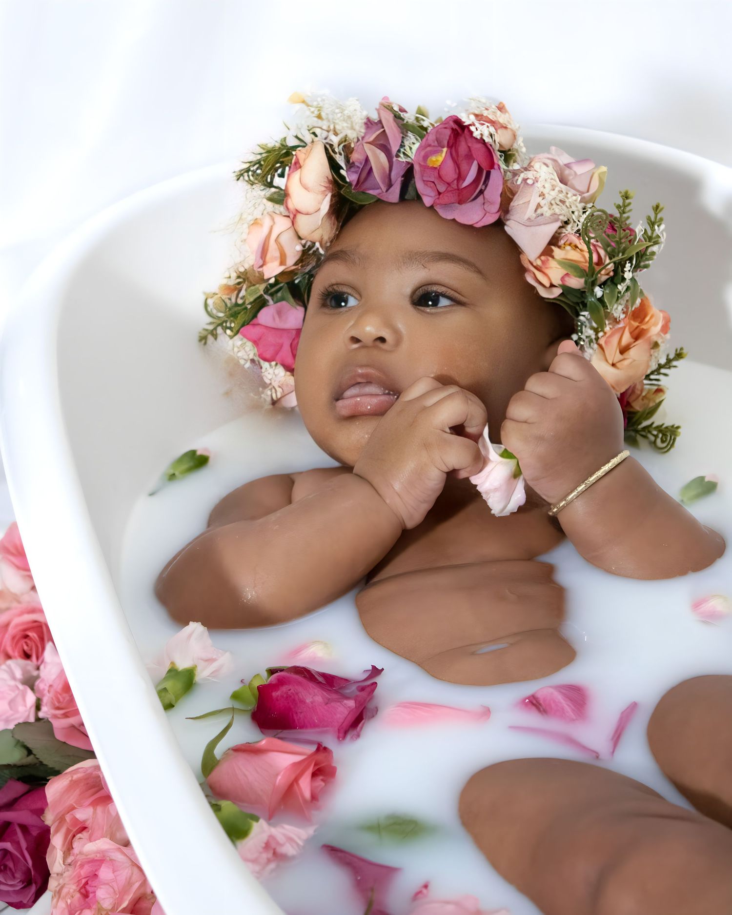 Milk bath portrait with pink roses and floral crown creating dreamy atmosphere.