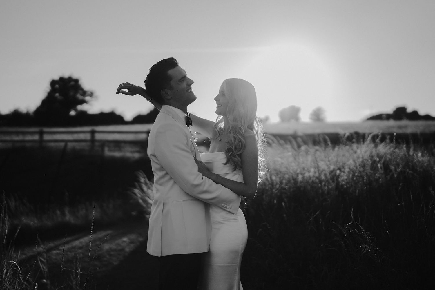 groom throwing head back laughing with bride during sunset at hamsell house wedding in bath