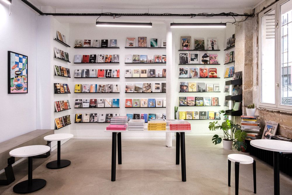 Bright bookstore interior with extensive wall shelving displaying colorful book covers.